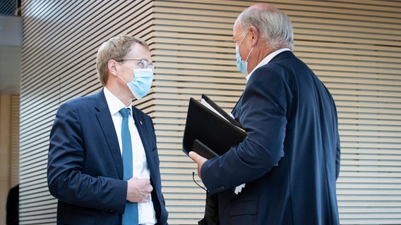 Daniel Günther (CDU, l), Ministerpräsident von Schleswig-Holstein, und Hans-Joachim Grote, Schleswig-Holsteins Ex-Innenminister, unterhalten sich am Rande einer Tagung des Innen- und Rechtsausschuss des Landtags Kiel. © dpa-Bildfunk Foto: Christian Charisius