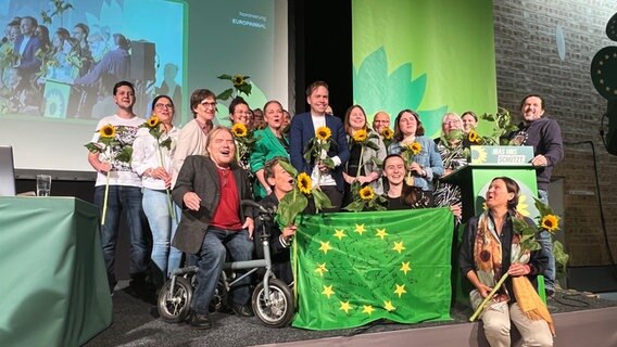 Verschiedene Mitglieder der Grünen stehen für ein Foto bei einem Landesparteitag in Neumünster auf der Bühne © NDR Foto: Friederike Hoppe