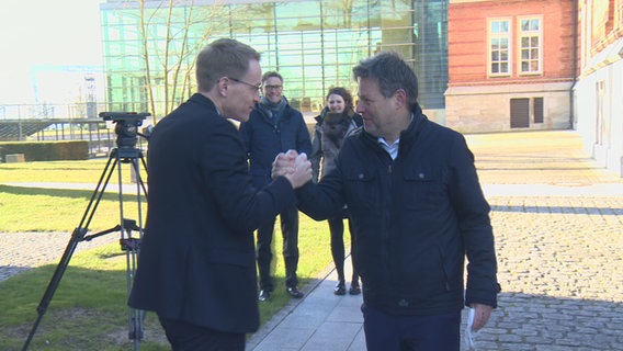 Daniel Günther und Robert Habeck begrüßen einander. © NDR 