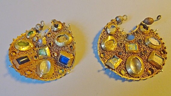 Zwei ausgegrabene goldene Ohrringe. © NDR Foto: Peer-Axel Kroeske