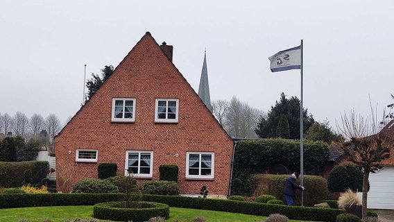 Vor seinem Haus hisst Günter Ahlers die Fahne der SG Flensburg-Handewitt. © NDR Foto: Peer-Axel Kroeske