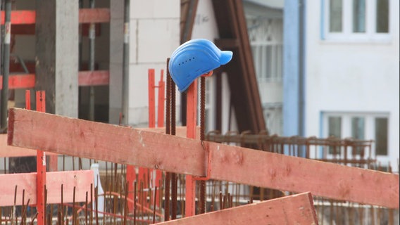 Helm steckt auf Zaun auf einer Baustelle © IMAGO Images Foto: BildFunkMV