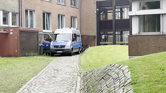 Ein Polizeiwagen steht hinter einem Gerichtsgebäude in Heide. © NDR 