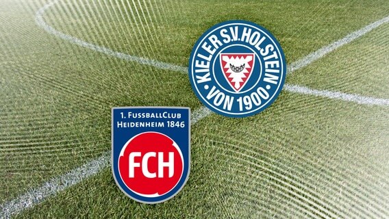 Das Vereinswappen vom 1. FC Heidenheim neben dem von Holstein Kiel vor Fussballrasen. © NDR 