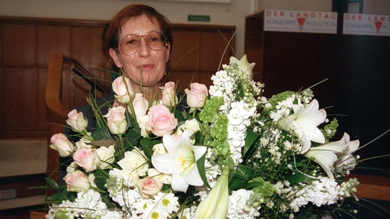 Die neue Ministerpräsidentin von Schleswig-Holstein, Heide Simonis, aufgenommen mit einem großen Blumenstrauß nach ihrer Vereidigung im Kieler Landtag am 19. Mai 1993. © picture-alliance/ dpa Foto: Stefan Hesse