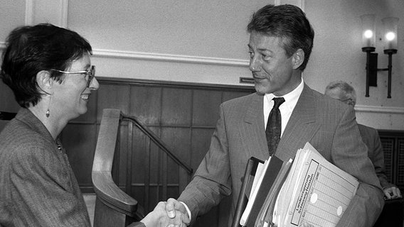Heide Simonis (l.) und der Ministerpräsident von Schleswig-Holstein, Björn Engholm (SPD), begrüßen sich am 6. September 1988 in Kiel. © picture-alliance/ dpa Foto: Wulf Pfeiffer