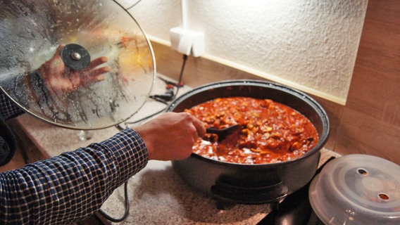 Ein Jugendlicher rührt in einem Kochtopf © NDR Foto: Christian Wolf