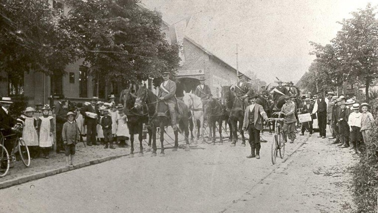 Findling-Transport in Henstedt-Ulzburg früher. Die Menschen sind mit Fahrrädern und vielen Pferden unterwegs. © Gemeindearchiv Henstedt-Ulzburg Foto: Gemeindearchiv Henstedt-Ulzburg
