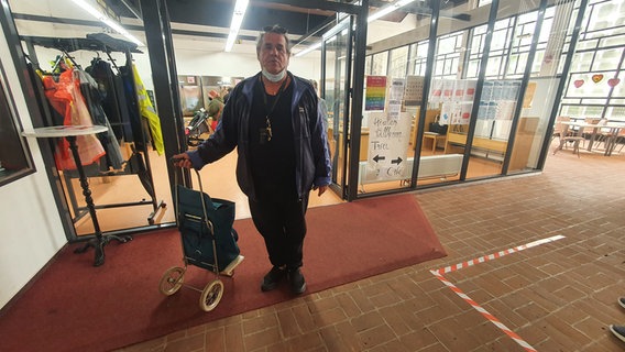 Ein Mann mit Einkaufstrolley steht in der Sozialkirche Kiel-Gaarden. © NDR Foto: Sebastian Parzanny