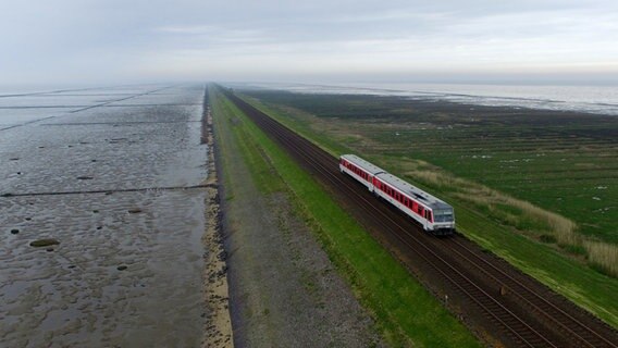 Ein Zug der Deutschen Bahn fährt über den Hindenburgdamm zwischen Sylt und Niebüll. © dpa-Bildfunk Foto: Carsten Rehder