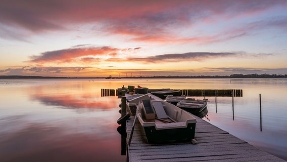Boote am Steg bei Sonnenaufgang am Groß Wittensee. © Johannes Rahe-Dechant Foto: Johannes Rahe-Dechant