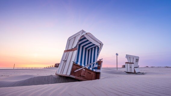 Strandkorb in Schieflage bei Sonnenuntergang an der Nordsee. © Dennis Siebert Foto: Dennis Siebert