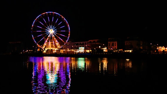 Ein Riesenrad bei Nacht am Hafen bei den Sprottentagen in Eckernförde. © Rüdiger Seemann Foto: Rüdiger Seemann