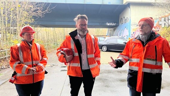 Verkehrsminister Madsen steht zwischen zwei Mitarbeitenden des LSV © NDR Foto: Christian Nagel