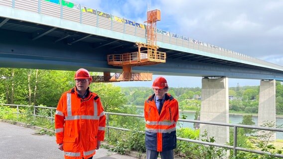 Zwei Bauarbeiter stehen vor der Olympiabrücke in Kiel während Reparaturarbeiten © NDR Foto: Christian Nagel