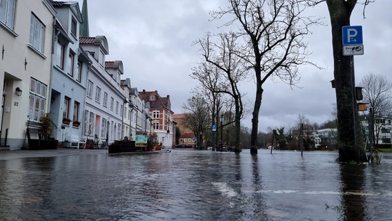 Stark überflutete Lübecker Straße mit einer Häuserzeile. © NDR Foto: Julian Marxen