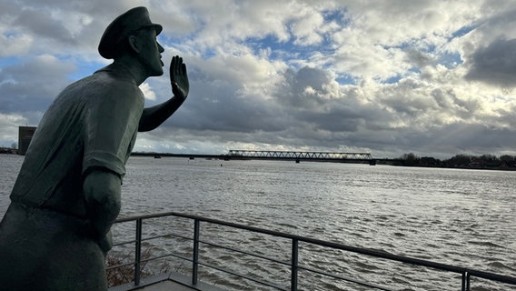 Eine Statue eines Mannes blickt auf die hochstehende Elbe in Lauenburg. © NDR Foto: Tobias Gellert
