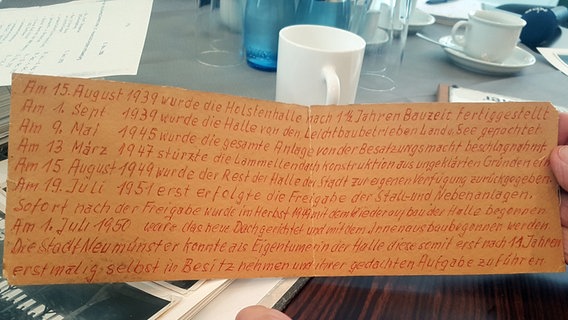 Auf einem alten Stück Pappe stehen von Hand geschrieben Termine diverser Veranstaltungen in den Holstenhallen von 1939 bis 1950. © NDR Foto: Cassandra jane Arden
