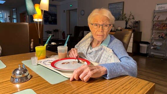 Eine Frau sitzt an einem Tisch und isst Suppe © NDR Foto: Johannes Tran