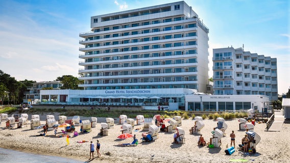 Urlauber sonnen sich am Strand vor dem Grand Hotel Seeschlösschen an der Ostsee in Timmendorfer Strand. © imago images Foto: Christian Ohde