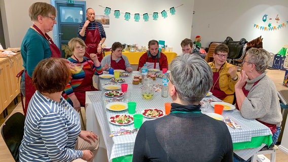 Mehrere Personen sitzen an einem Tisch für ein gemeinsames Abendessen © NDR Foto: Lena Haamann