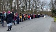 Zahlreiche Menschen bilden eine lange Menschenkette auf dem Zufahrtsweg der Imland-Klinik in Eckernförde für eine Protestaktion. © NDR Foto: Paul Wessels