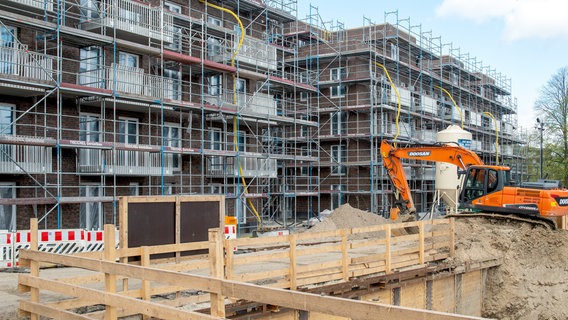 Ein Bagger steht vor einem Hausneubau in Schleswig. © picture alliance / SULUPRESS.DE Foto: Torsten Sukrow