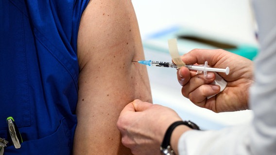 Eine Pflegekraft an einem Uniklinikum in Hessen erhält eine Covid-Impfung. © dpa pool/dpa +++ dpa-Bildfunk Foto: Andreas Arnold