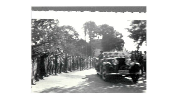 Eine eingescannte schwarz weiß Fotografie. Hitler mit seinem Convoi und Menschen die den Hitlergruß machen. © Ingelene Rodewald 