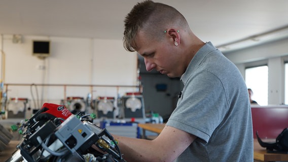 Ein Mann arbeitet an Maschinen. © NDR Foto: Natalie Beck