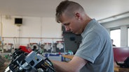 Ein Mann arbeitet an Maschinen. © NDR Foto: Natalie Beck