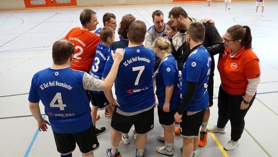 Die Handballspieler des SC Gut Heil Neumünster versammelt in einem Kreis. © NDR Foto: Samir Chawki