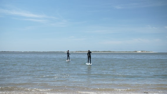 Zwei Stand-Up-Paddler auf der Nordsee, eine Insel am Horizont © NDR Foto: Dominik Dührsen