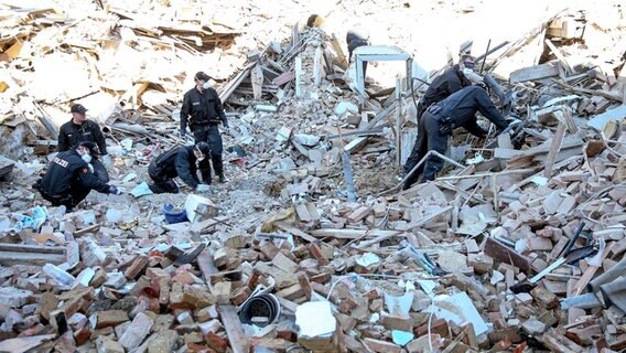 Polizisten durchsuchen die Trümmer eines eingestürzten Hauses in Itzehoe © dpa Bildfunk Foto: Axel Heimken
