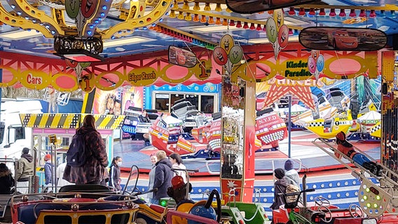 Fahrgeschäfte auf dem Jahrmarkt in Flensburg. Im Vordergrund ein Karussell, im Hintergrund der "Breakdancer".  Foto: Peer-Axel Kroeske