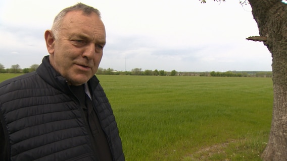 Landwirt Hermann Jürgensen steht am Rande eines Ackers bei einem Interview. © NDR 