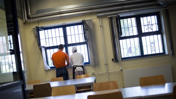 Zwei junge Häftlinge stehen in Schleswig (Schleswig-Holstein) an einem vergitterten Fenster in der Kantine des Jugendgefängnisses und unterhalten sich wärend einer kurzen Pause © dpa Foto: Christian Charisius