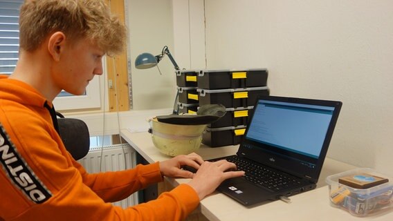 Ein Jugendlicher sitzt an einem Laptop und tippt.  Foto: Stella Kennedy