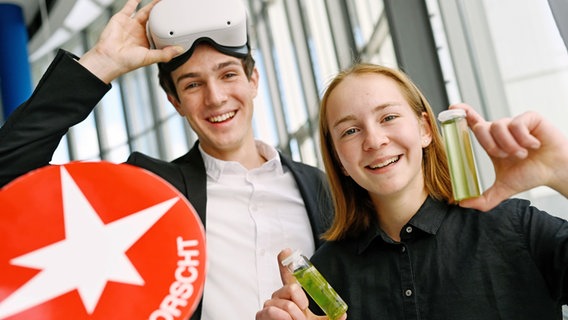 Ein junger Forscher trägt eine Virtual-Reality-Brille und eine junge Forscherin hat zwei Reagenzgläser mit Algen in der Hand. © Stiftung Jugend forscht e. V. Foto: Stiftung Jugend forscht e. V.