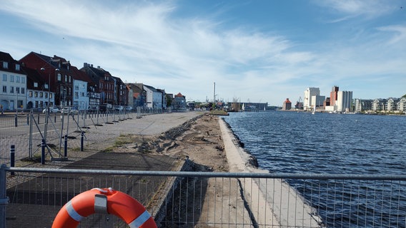 Die Flensburger Promenade am Hafen ist hinter einem Gitter nicht mehr gepflastert. © NDR Foto: Peer-Axel Kroeske