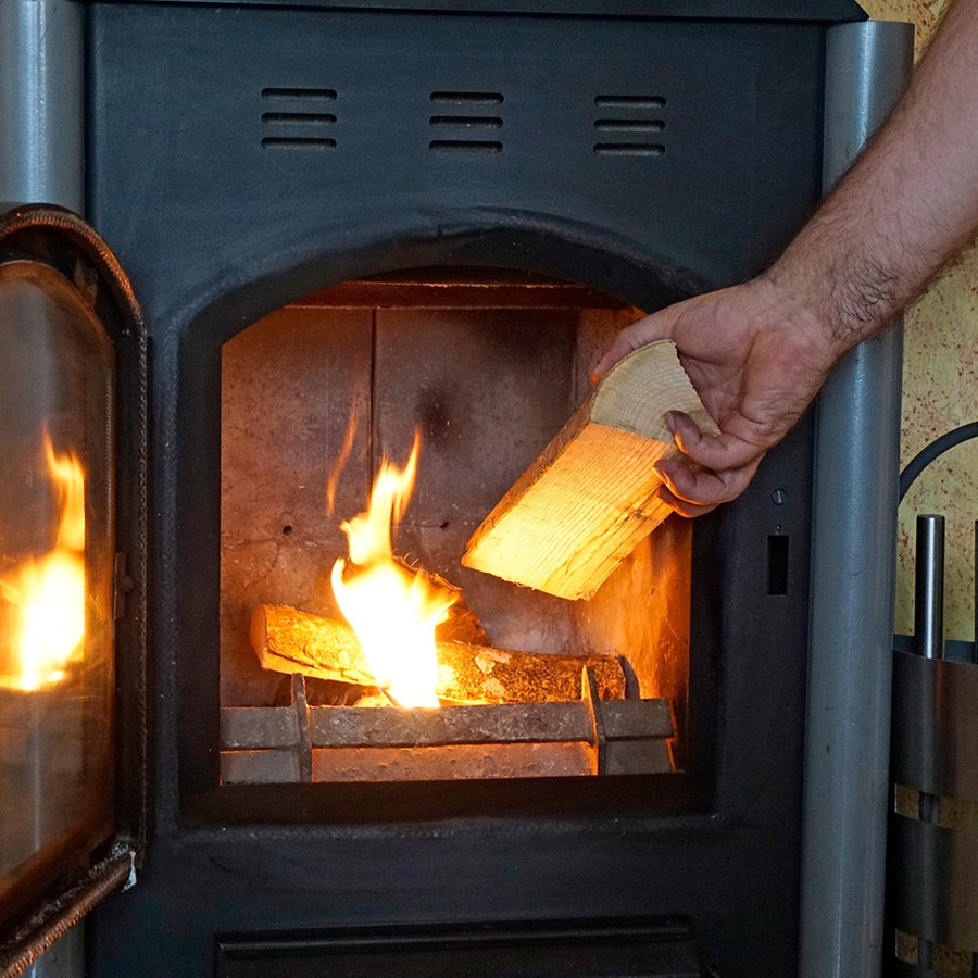 Ein Holzofen in einem Wohnzimmer in Betrieb. © picture alliance / M.i.S. Foto: Bernd Feil
