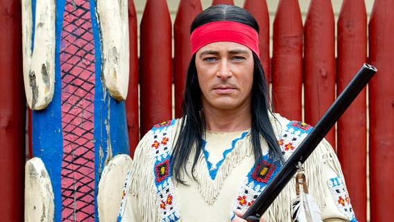 Jan Sosniok in der Rolle des Winnetou hält ein Gewehr, Karl-May-Spiele Bad Segeberg 2013. © picture alliance / dpa Foto: Sven Hoppe