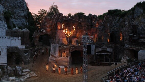 Zuschauer sitzen in der Kalkberg-Arena bei der Premiere von "Winnetou Blutsbrüder" bei den Karl-May-Spielen in Bad Segeberg in der Dämmerung. Zuschauer sitzen in der Kalkberg-Arena bei der Premiere von "Winnetou Blutsbrüder" bei den Karl-May-Spielen in Bad Segeberg in der Dämmerung. © NDR Foto: Doreen Pelz