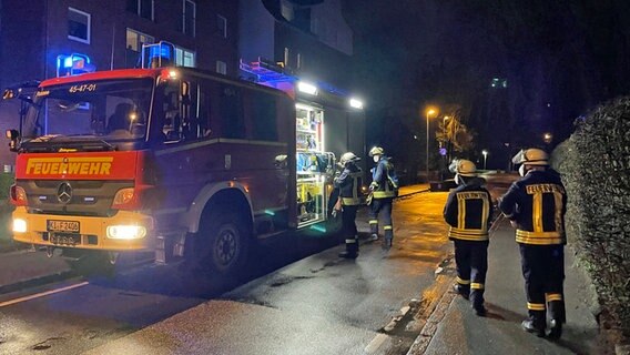 In einer Straße in Kiel-Hassee steht ein Feuerwehrauto, Einsatzkräfte stehen davor. © NDR Foto: Christian Wolf