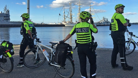 Vier Beamten der der Fahrradstaffel der Polizei sind mit ihren Fahrrädern an der Kiellinie unterwegs. © NDR Foto: Friedericke Schneider