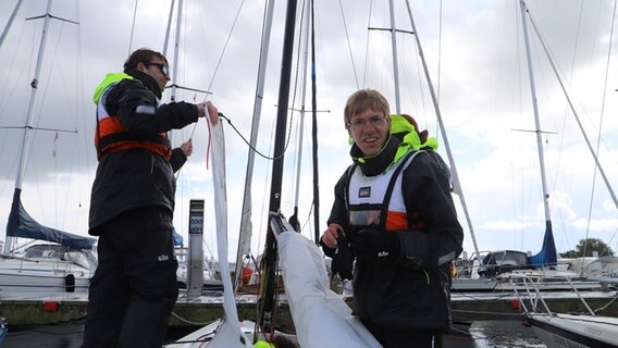 Leon und Alexander Tyssen arbeiten am Hafen auf einem Segelboot. © NDR Foto: Marina Heller