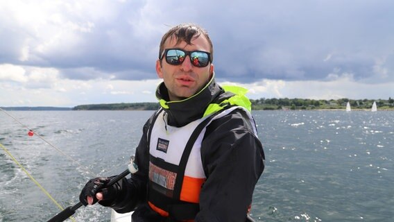 Alexander Tyhssen steuert ein Segelboot auf dem Wasser. © NDR Foto: Marina Heller