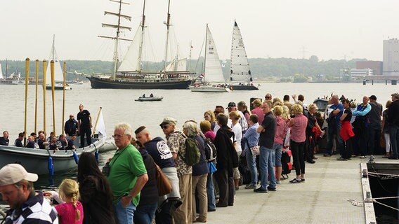 Eine Menschenmenge am Kieler Hindenburgufer beobachtet die Windjammerparade © NDR Foto: Yosua Pandelaki