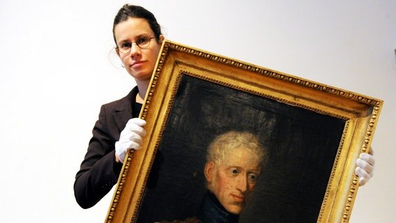 Kuratorin Sonja Kinzler zeigt im Stadtmuseum von Kiel ein Bild des dänischen Königs Friedrich VI © dpa Bildfunk Foto: Carsten Rehder