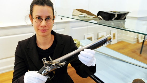 Kuratorin Sonja Kinzler zeigt im Stadtmuseum von Kiel eine dänische Reiterpistole © dpa Bildfunk Foto: Carsten Rehder